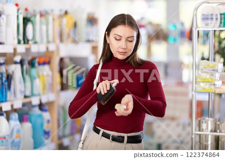 Young woman chooses perfume in store Young woman chooses perfume in store 122374864