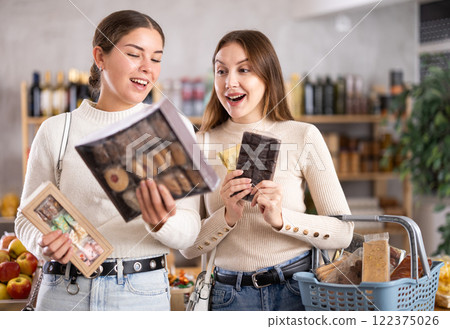 Two girls in store while shopping, choose sweets and chat sweetly 122375026