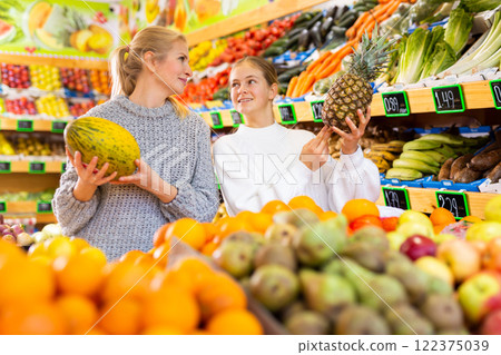 Friendly teenage girl and her mother shopping in fruit store Friendly teenage girl and her mother shopping in fruit store 122375039