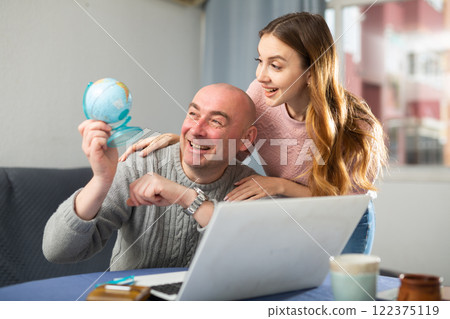 Happy married couple, attentive examines a globe Happy married couple, attentive examines a globe 122375119