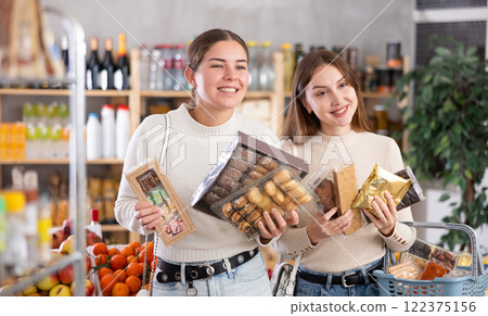 Two girls in store while shopping, choose sweets and chat sweetly 122375156