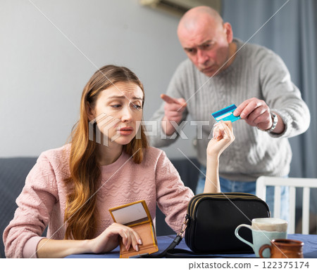 Sad woman giving back credit card to her husband 122375174