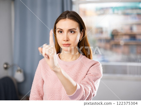 Portrait of a young woman performing a gymnastic exercise for the eyes Portrait of a young woman performing a gymnastic exercise for the eyes 122375304
