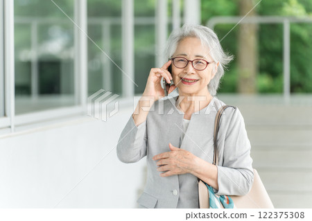 高級女商人/老年婦女(活躍的高級)在智慧型手機上交談 高級女商人/老年婦女(活躍的高級)在智慧型手機上交談 122375308