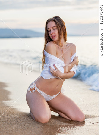 Close up portrait of beautiful young woman on the beach. Young caucasian female model on sea shore Close up portrait of beautiful young woman on the beach. Young caucasian female model on sea shore 122375445