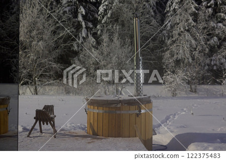 Experience the delightful charm of a Wooden Hot Tub set in a breathtaking Winter Wonderland 122375483