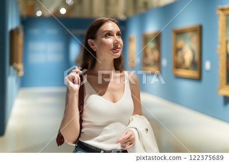 Girl view pictures and icons in museum hall 122375689