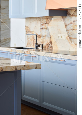 This kitchen has a stunning marble backsplash and light blue cabinets for a stylish feel This kitchen has a stunning marble backsplash and light blue cabinets for a stylish feel 122376414