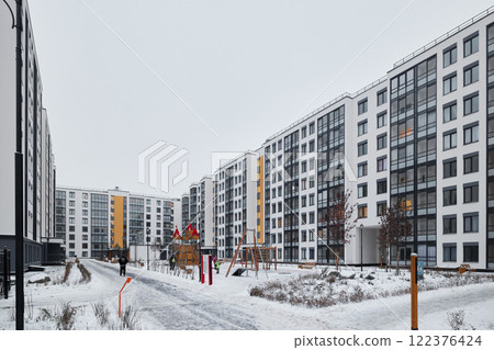 A Modern Apartment Complex Nestled Within a Beautiful Winter Landscape Featuring Snow and Serenity 122376424