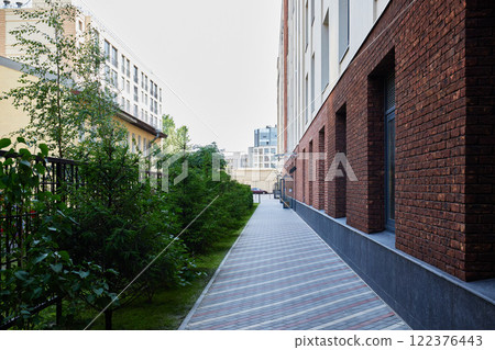 A modern urban pathway enriched with vibrant greenery and beautiful brick architecture 122376443
