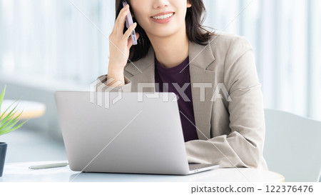 Smiling woman/businesswoman talking on smartphone 122376476