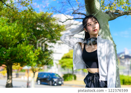 A cool woman leaning against a tree and walking, posing, diet, walking, exercise A cool woman leaning against a tree and walking, posing, diet, walking, exercise 122376599