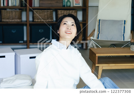 Woman looking outside from the living room Woman looking outside from the living room 122377308