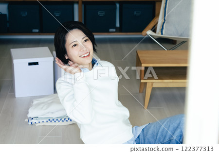 Woman looking outside from the living room Woman looking outside from the living room 122377313