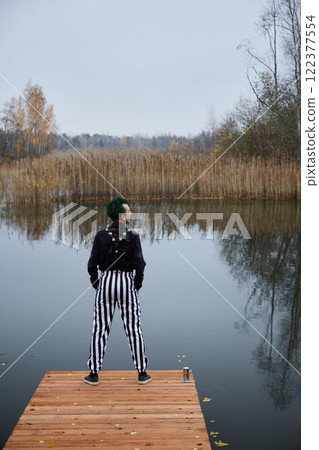 A Contemplative Figure by the Water while Wearing Striped Trousers in Autumnal Scenery A Contemplative Figure by the Water while Wearing Striped Trousers in Autumnal Scenery 122377554