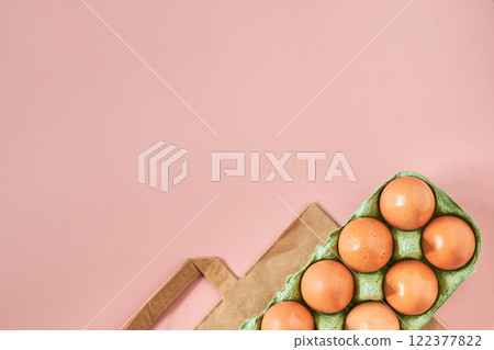 Kraft bag with chicken eggs in tray on beige background, shopping concept, space for text 122377822