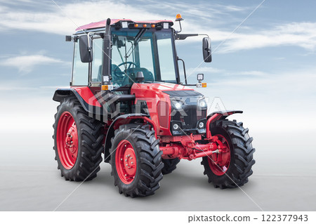 Red modern wheeled tractor isolated on bright background with sky 122377943