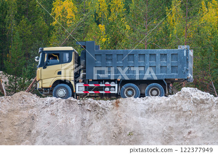Empty dump truck on a clay quarry next to the autumn forest Empty dump truck on a clay quarry next to the autumn forest 122377949