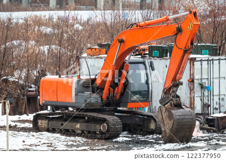 Orange crawler excavator at a construction site at winter 122377950