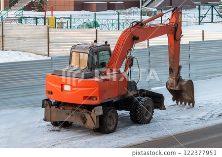 Orange wheeled excavator in the countryside in winter Orange wheeled excavator in the countryside in winter 122377951