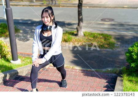 A cool woman stretching her legs on the stairs along the river, walking, diet, walk, exercise 122378143