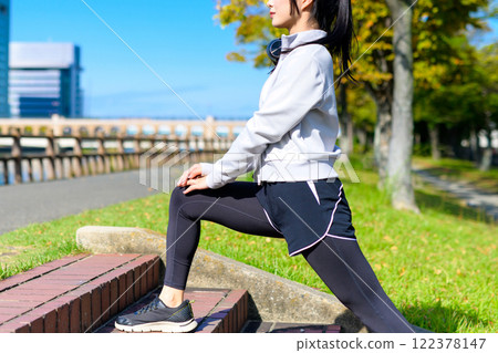 A cool woman stretching her legs on the stairs along the river. Walking, dieting, walking, exercise, trimming 122378147
