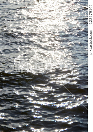 The enchanting and glittering reflections of water on a calm and inviting surface 122379143