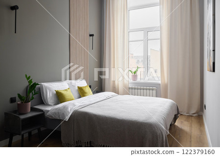 A Stylish and Minimalist Bedroom that Boasts Abundant Natural Light and Lush Greenery 122379160