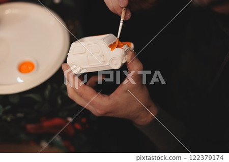 An Artistic Individual Skillfully Hand Painting a Detailed Model Car with Various Colors An Artistic Individual Skillfully Hand Painting a Detailed Model Car with Various Colors 122379174