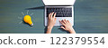Person using a laptop computer and a light bulb 122379554