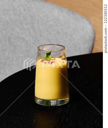 Enjoy a Refreshing Mango Smoothie topped with beautiful, vibrant Edible Flowers for a unique treat Enjoy a Refreshing Mango Smoothie topped with beautiful, vibrant Edible Flowers for a unique treat 122380312