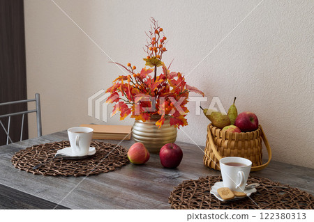 A Beautiful Autumn Table Setting Featuring an Elegantly Arranged Display of Flowers and Fresh Fruits A Beautiful Autumn Table Setting Featuring an Elegantly Arranged Display of Flowers and Fresh Fruits 122380313