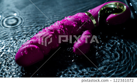 Pink ribbed vibrator in water. Circles on water around sex toy. Pink ribbed vibrator in water. Circles on water around sex toy. 122381072