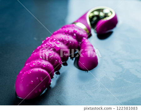 Wet pink ribbed vibrator in water. 122381083