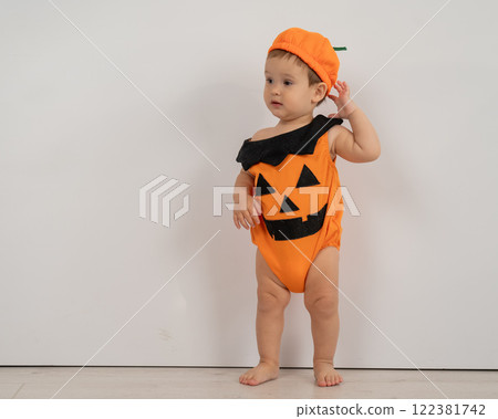 Cute Caucasian boy in pumpkin costume for Halloween.  122381742