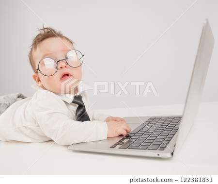 Cute baby in glasses and suit working on laptop. Cute baby in glasses and suit working on laptop. 122381831