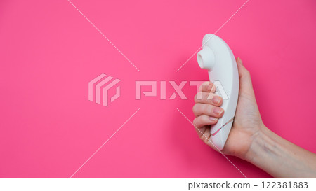 Woman holding white vacuum clitoral vibrator on pink background. Woman holding white vacuum clitoral vibrator on pink background. 122381883