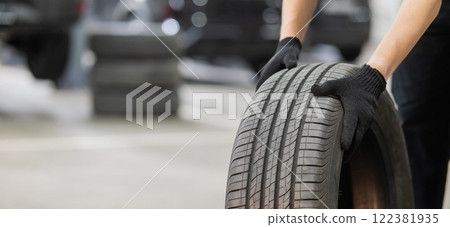 Man holding old car tire. Close up of mechanic's hands with wheel. Man holding old car tire. Close up of mechanic's hands with wheel. 122381935