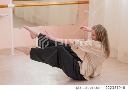Caucasian woman dancing contemporary on the floor in a ballet class. Caucasian woman dancing contemporary on the floor in a ballet class. 122381946