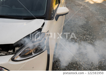 Smoke is coming from under the hood of the car. Smoke is coming from under the hood of the car. 122381950