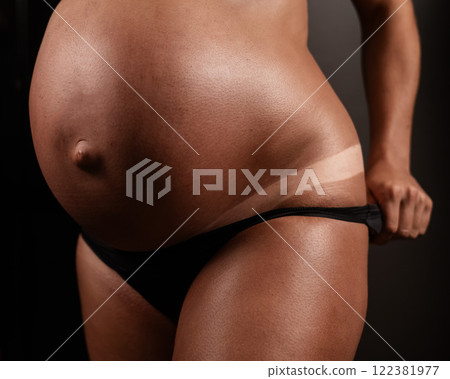 Pregnant woman pulls back her panties showing instant tan.  122381977