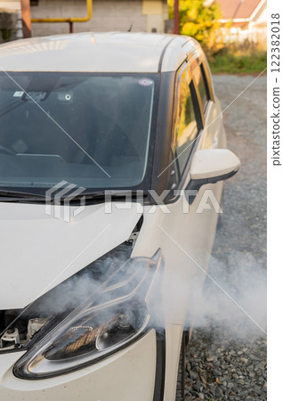 Smoke is coming from under the hood of the car.  122382018