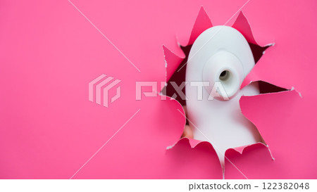 White vacuum clitoral vibrator sticking out through pink paper background. Sex toy. White vacuum clitoral vibrator sticking out through pink paper background. Sex toy. 122382048