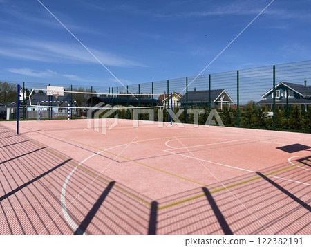 An Outdoor Volleyball Court Set Against a Stunning Clear Blue Sky Above is Ready for Action 122382191