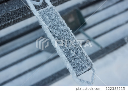 A frosted bench stands out in a winter wonderland, captured in breathtaking artistry 122382215