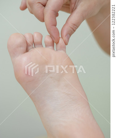 Close up of a woman's foot being massaged. Close up of a woman's foot being massaged. 122382221