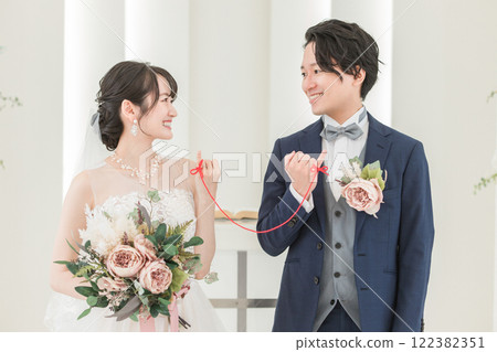 A bride and groom tied with a red thread at a wedding hall (bridal wedding) 122382351