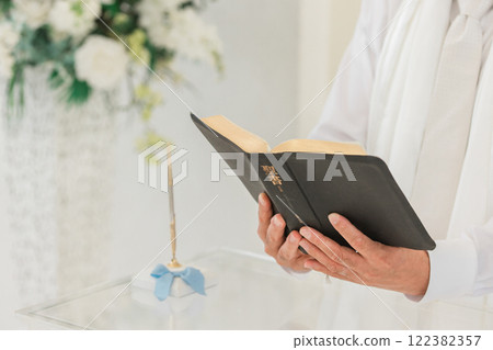 Priest's hands holding a Bible in a chapel or church (wedding, wedding, church) 122382357