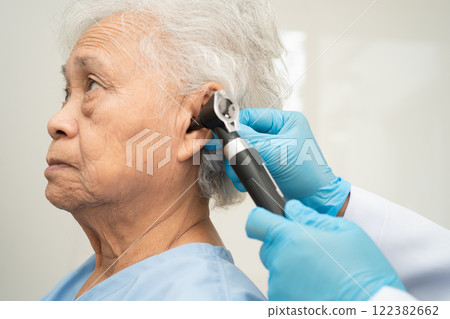 Otolaryngologist or ENT physician doctor examining senior patient ear with otoscope, hearing loss problem. Otolaryngologist or ENT physician doctor examining senior patient ear with otoscope, hearing loss problem. 122382662