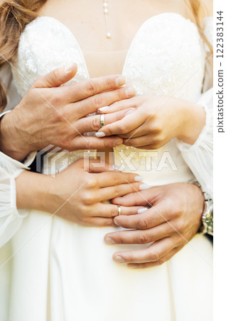 two gold wedding rings. the bride wears the groom wedding ring. newlyweds with rings on fingers. 122383144